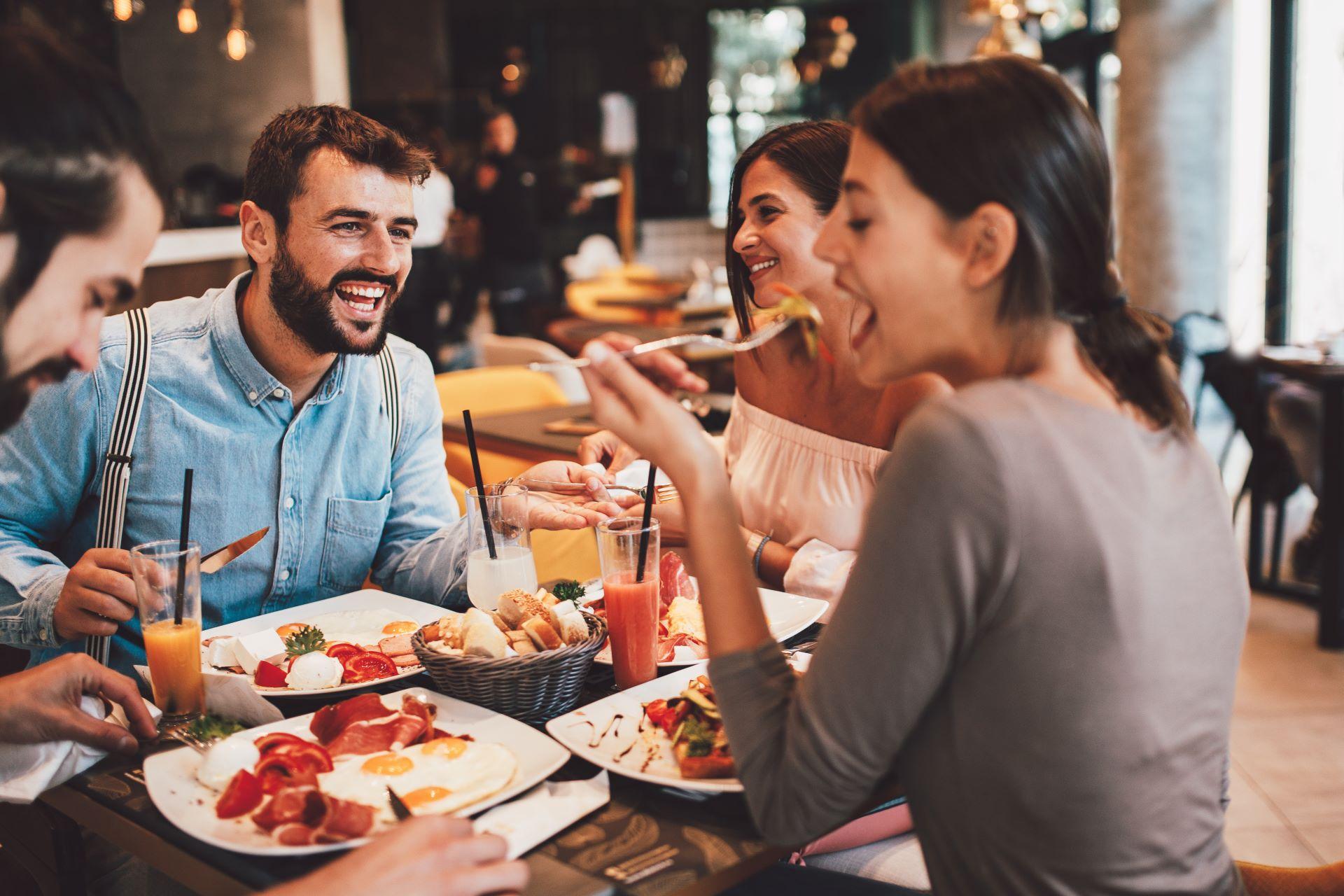 Gruppe von glücklichen Freunden beim Frühstück im Restaurant