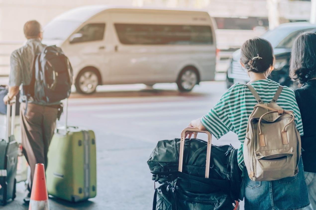 Reisende mit Gepäck warten auf Shuttle-Service für Langzeitparken am Flughafen Nürnberg