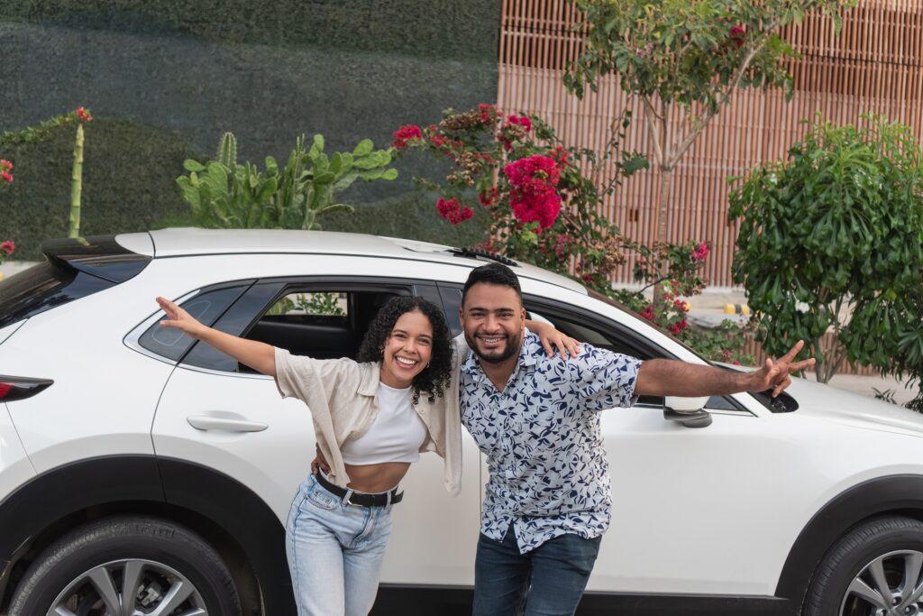 Paar posiert fröhlich vor Mietwagen im Urlaub | Anwalt Verkehrsrecht Dresden